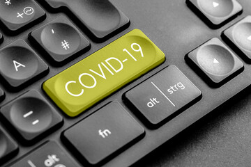 gelbe Covid 19 Taste auf einer dunklen Tastatur