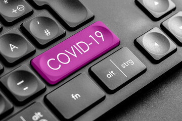 lila Covid 19 Taste auf einer dunklen Tastatur