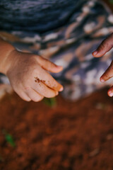 the boy's hand was playing on the dirty ground