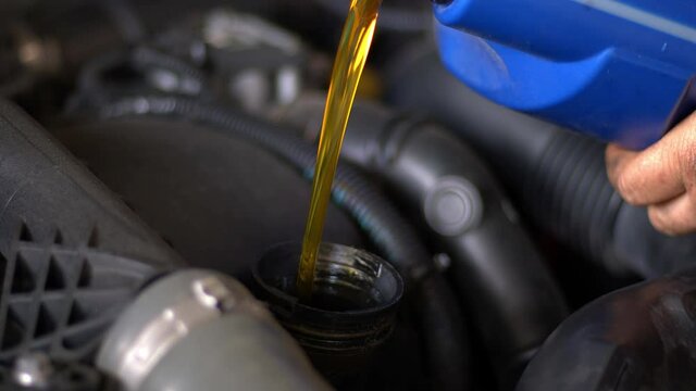 Motor Synthetic Oil Pouring To Car Engine. Synthetic Oils for Protecting Cars Engine Footage.