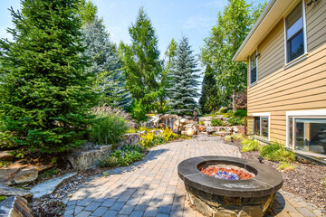 Lush landscaping including a fire pit and pond with waterfall in a luxury North Idaho, USA home.
