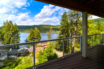 View of Liberty Lake and the mountains from an upscale home's covered deck in neighborhood of homes in Liberty Lake, Washington, USA