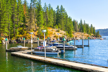 Fototapeta na wymiar Boats, wave runners and watercraft docked at a marina along Tubbs Hill on Lake Coeur d'Alene in Coeur d'Alene, Idaho USA