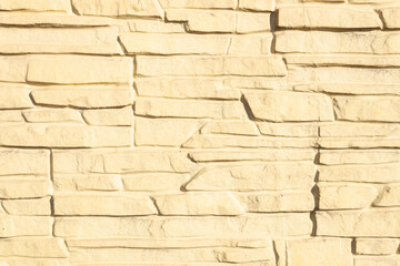 beige wall of decorative stones, made in the likeness of masonry