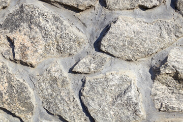 various types of stones are stacked and poured into a pattern for a decorative wall