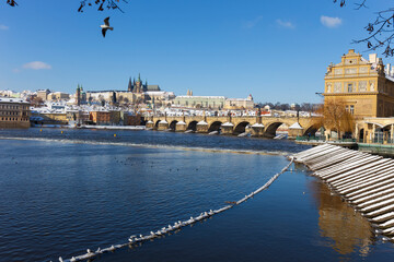Snowy Prague Lesser Town with Prague Castle and Charles Bridge above River Vltava in the sunny Day , Czech republic