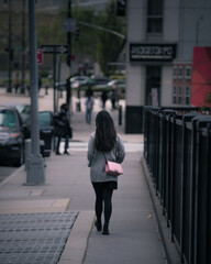 Girl walking alone with bright pink purse