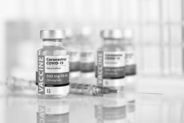 Coronavirus COVID-19 Vaccine Vials and Syringe On Reflective Surface