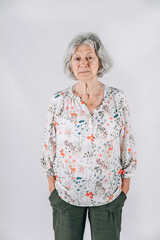 Sad widow elderly woman in her 80's with Gray hair standing isolated on a white backdrop
