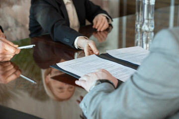 Hand of mature female delegate passing contract of international partnership