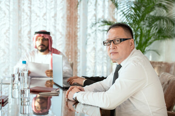 Serious mature business delegate in eyeglasses and formalwear looking at you