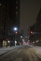 Urban cityscape during night time with city streets during snowstorm in the winter