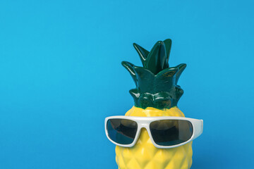 Pineapple wearing black glasses on a blue background.