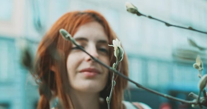 Woman looking at a flower and smiling