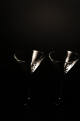 Two empty cocktail glasses on a black background. Studio shooting.