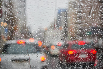 雨の日に車のフロントガラスから見た町風景