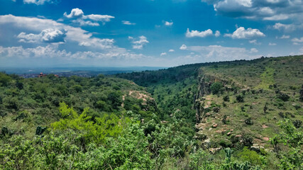 Fototapeta na wymiar paisaje desde una montaña cubierta en verde con un cañón