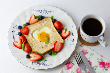Heart shape sunny side up bread toast breakfast with fruits