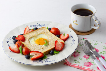 Heart shape sunny side up bread toast breakfast with fruits