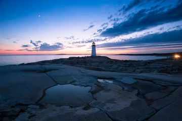 Photo sur Aluminium Blue nuit The Peggy's Cove Lighthouse landscape along the rugged rocks of the Atlantic Coast Nova Scotia Canada. The most visited tourist location in the Atlantic Canada and famous Lighthouse captured with vibr