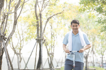 Asian man middle aged playing scooter in city park in concept healthy strong insurance retire Financial freedom