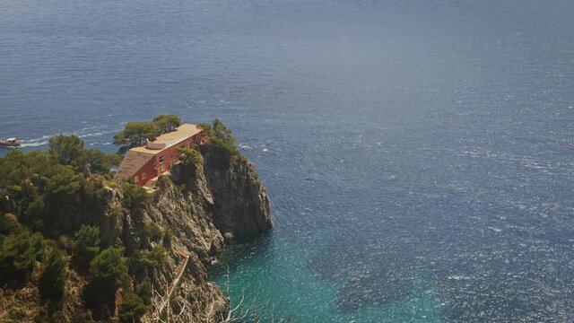 Tourists boat pass near villa Malaparte in Capri during a sunny day. Timelapse like tilt and shift effect.