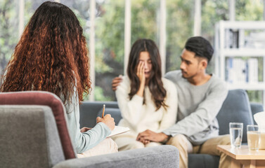 Reaw view of coach listening and writing note to the asian young lovers are sadness about their...