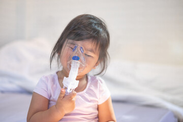 Closeup asian face little children girl sick he using steam inhaler nebulizer mask inhalation oneself, health medical cares