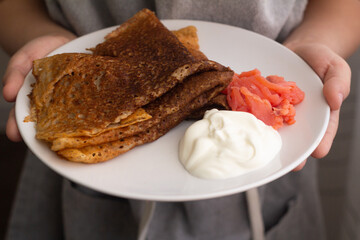 person holding a plate of pancakes