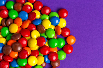 Fototapeta na wymiar Pile of Rainbow Colored Candy Coated Chocolate Buttons