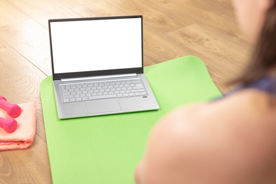 Back view of woman relax at home enjoy yoga online training practice course on mockup laptop, woman watch fitness sports workout video using modern internet application on computer