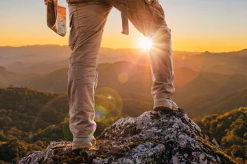 Meubelstickers Hiker standing on top mountain sunset background. Hiker men's hiking living healthy active lifestyle. © AungMyo