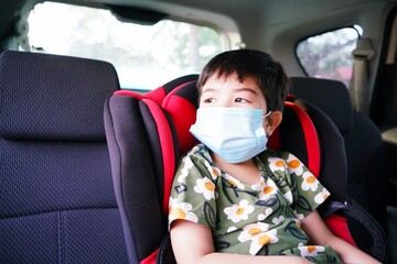 asian girls are looking outside the car wearing masks 