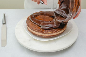 Chef pouring chocolate glaze on top of cake. Chocolate cake step by step recipe