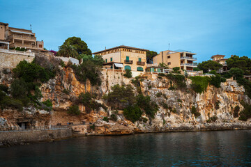 Fototapeta na wymiar Houses on a cliff in the Porto Cristo bay on Mallorca island in Spain at evening