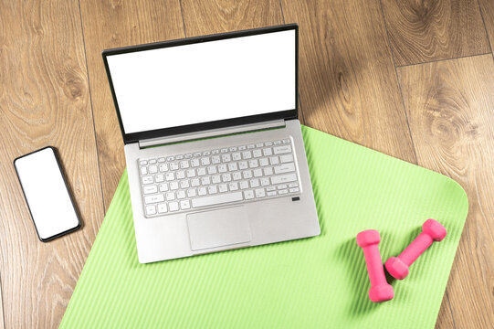 Mockup image Sports online workouts at home gym using computer or phone and sporty accessories. Online Laptop Yoga Home Fitness Workout