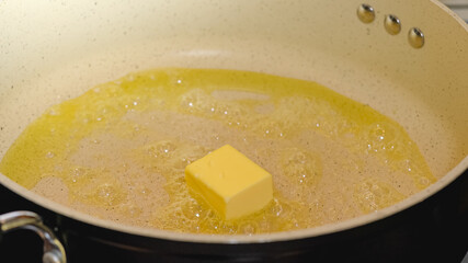 Frying pan with melted butter close up, cooking process