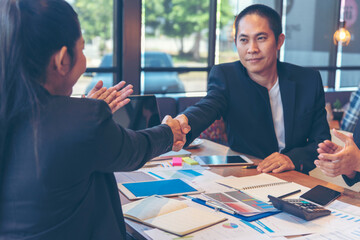 Team Business Partners shaking hands together to Greeting Start up small business in meeting room. Shakehand teamwork partners at modern office handshake together. Business mergers and acquisitions