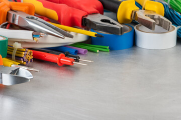 Tools and accessories used to electrical Installation on grey metal workshop table