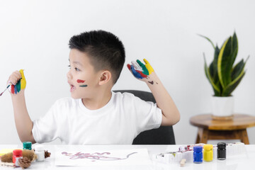 Happy little kid at the table draw with watercolor Learning and education of kid.
