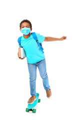 Little African-American schoolboy in medical mask and with skateboard on white background. Coronavirus epidemic