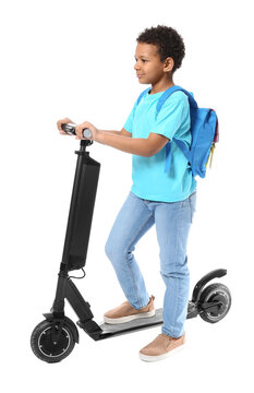 Little African-American schoolboy with kick scooter on white background