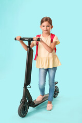 Little schoolgirl with kick scooter on color background © Pixel-Shot