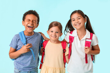 Happy little schoolchildren on color background