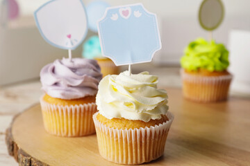 Tasty cupcakes with stylish toppers on wooden background