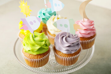 Tasty cupcakes with stylish toppers on light background