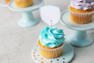 Tasty cupcakes with stylish toppers on light background