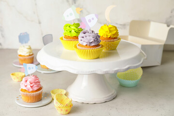 Tasty cupcakes with stylish toppers on light background