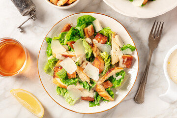 Caesar salad overhead flat lay shot. Grilled chicken breast slices, green romaine salad leaves, croutons and parmesan, the classic recipe - obrazy, fototapety, plakaty