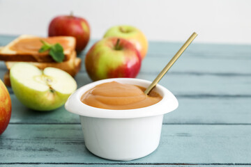 Bowl with sweet apple jam on color wooden background